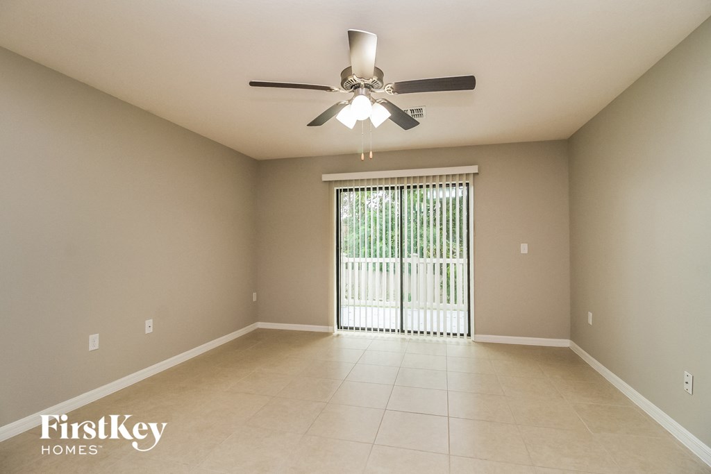 an empty living room with a ceiling fan