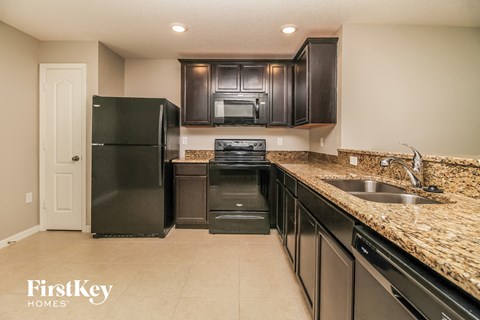a kitchen with black appliances and granite counter tops