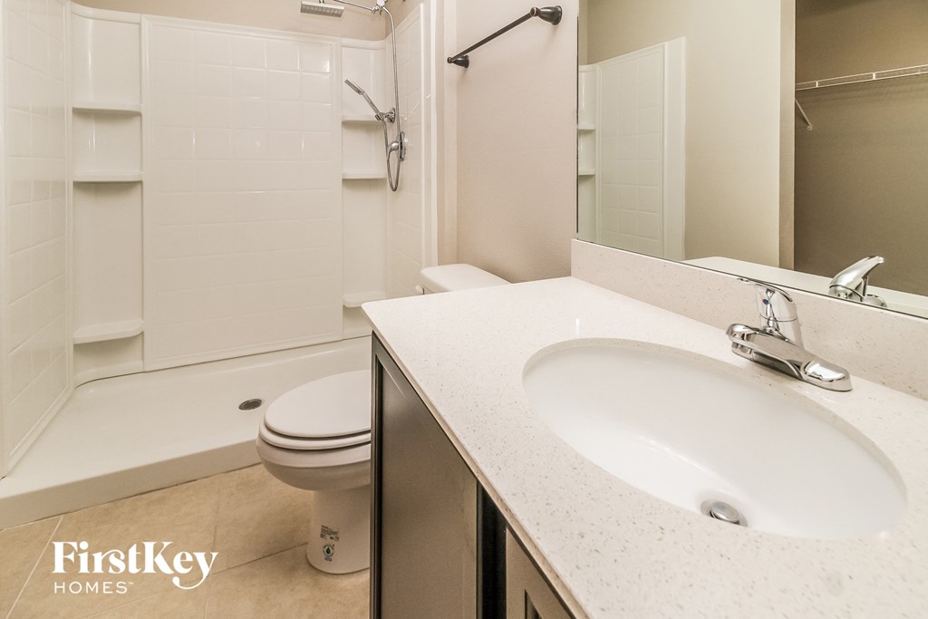 a bathroom with a sink and a toilet and a shower