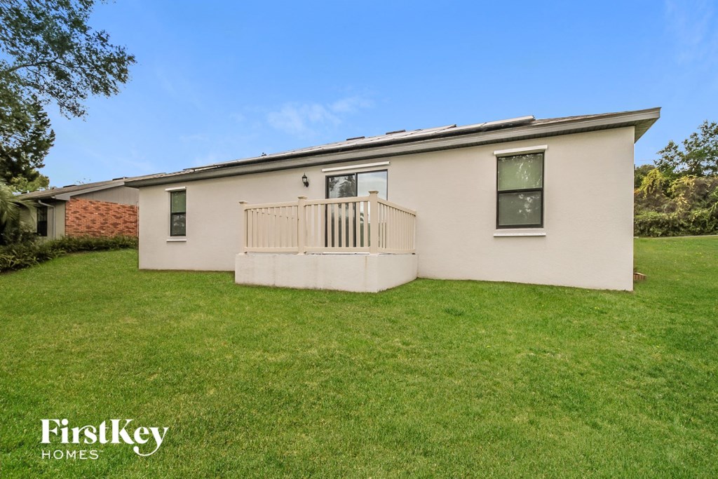 a small white house with a yard and a porch
