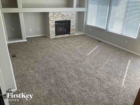 a living room with a fireplace and a carpeted floor