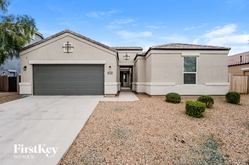a beige house with a driveway and a garage door