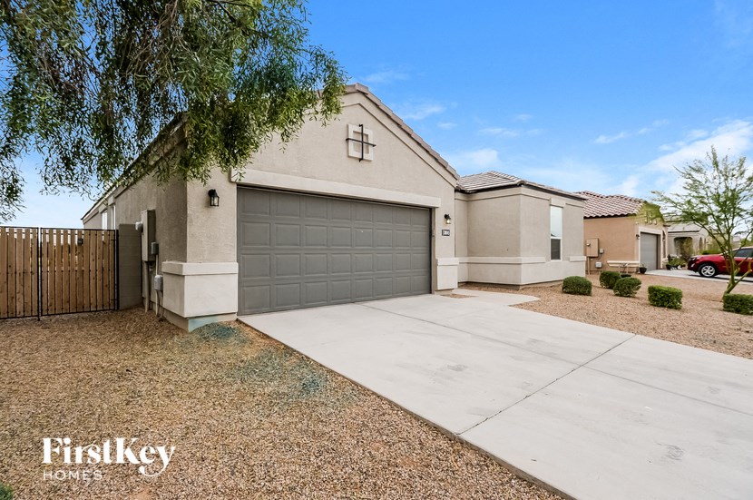 a beige house with a driveway and a garage door