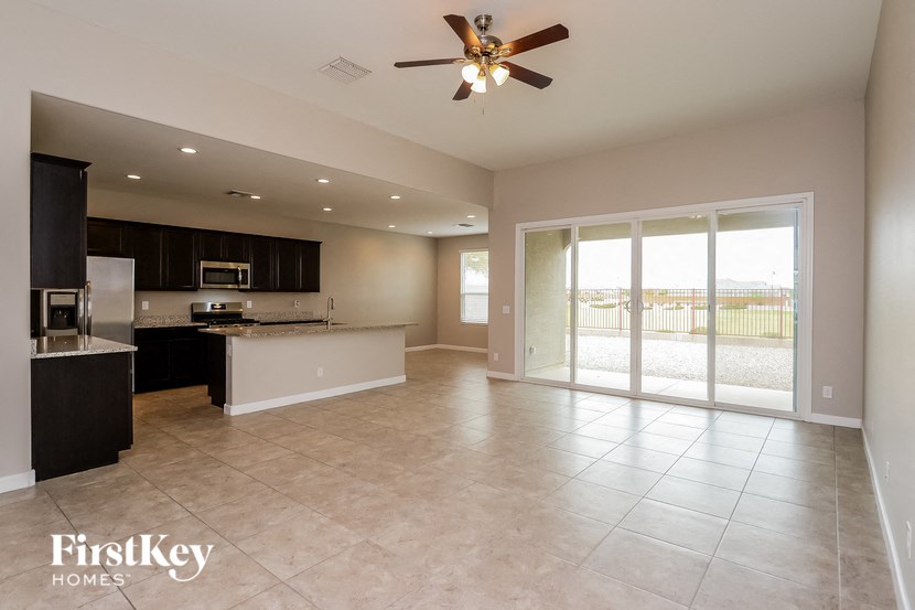 an open kitchen and living room with sliding glass doors to a balcony