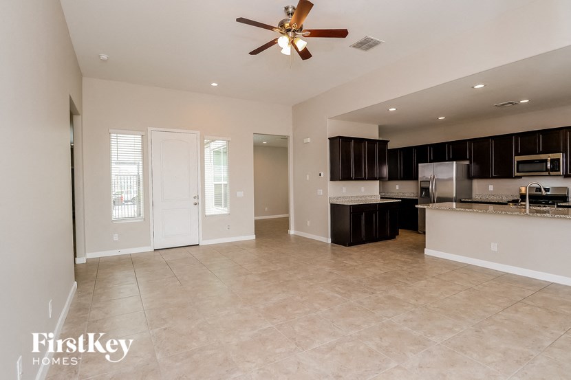 an empty kitchen and living room with a ceiling fan