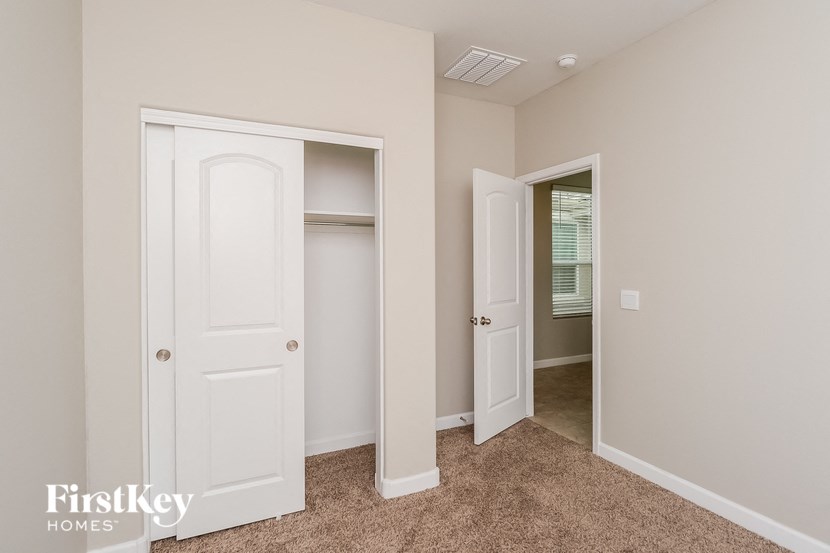 a bedroom with two closets and a hallway with two doors