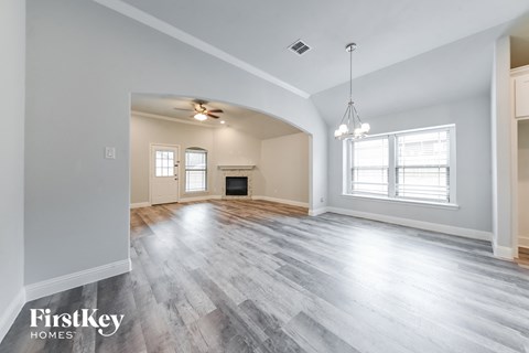 the living room and dining room with wood flooring and a fireplace