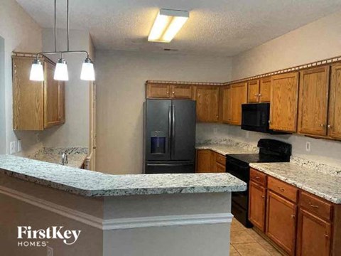 A kitchen with wooden cabinets and a granite countertop.