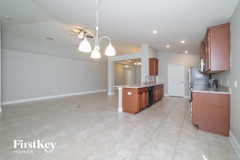 a kitchen and living room with wood cabinets and tile flooring