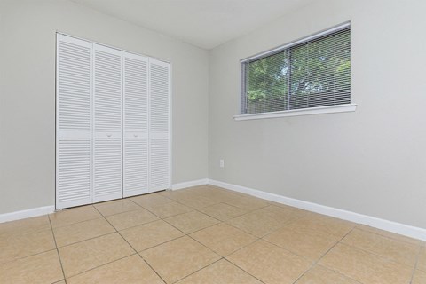 an empty room with a window and a tiled floor