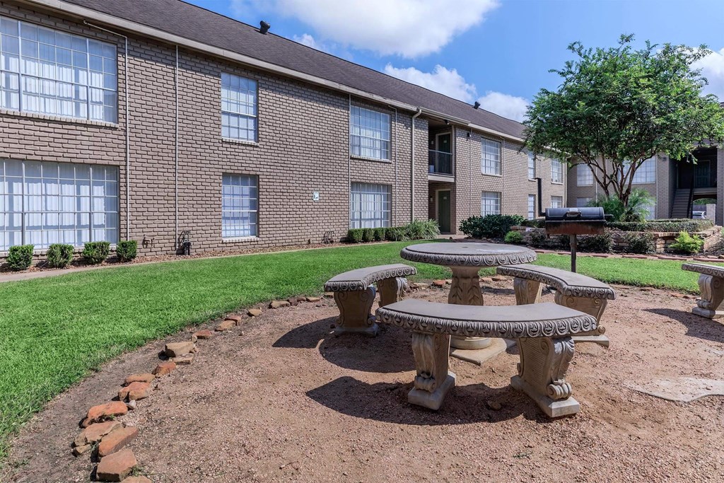 an outdoor seating area in front of a brick building