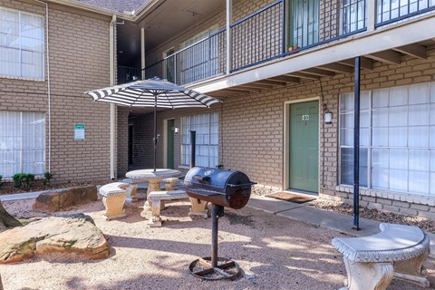 our apartments have a patio with a grill and an umbrella