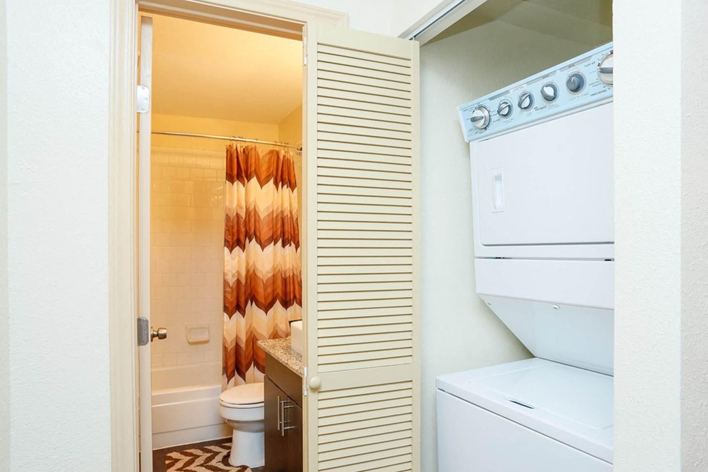a bathroom with a washer and dryer and a closet