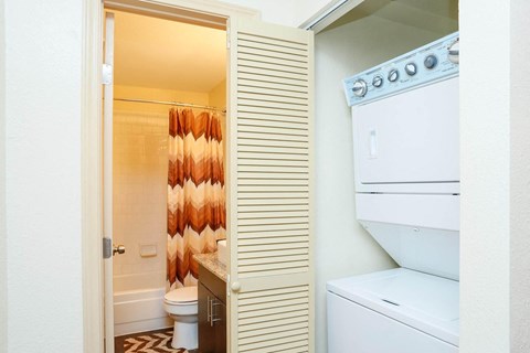 a bathroom with a washer and dryer and a closet