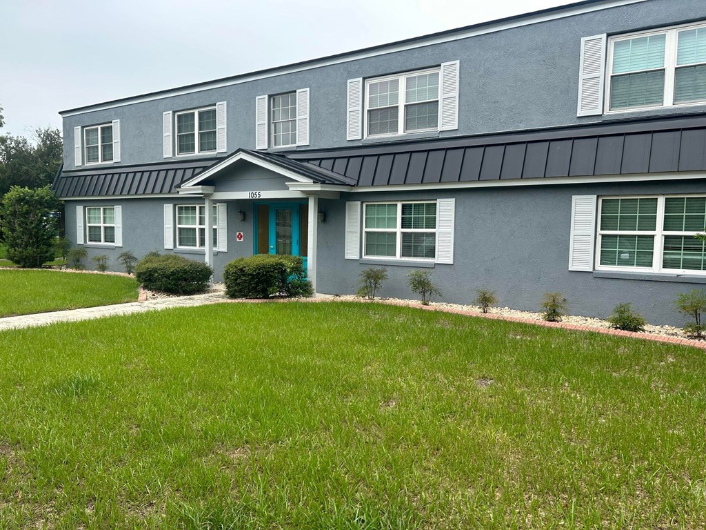 a blue house with a green lawn in front of it