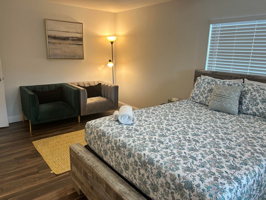 a bedroom with a bed and a couch and a window