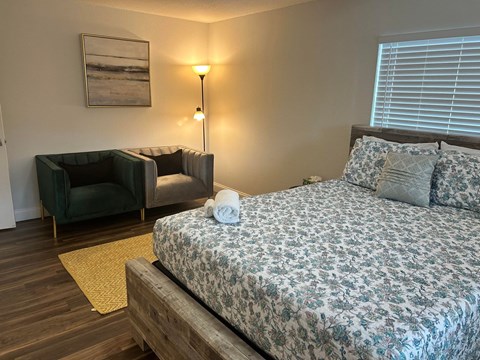 a bedroom with a bed and a couch and a window