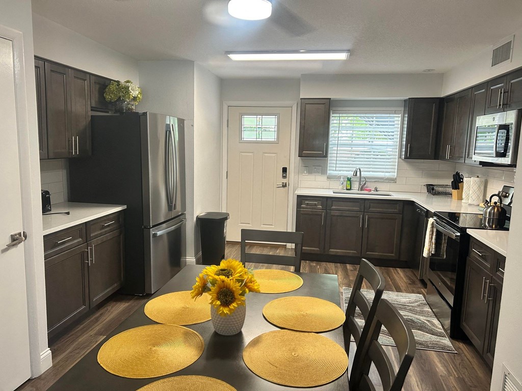 an open kitchen and dining room with a table and sunflowers