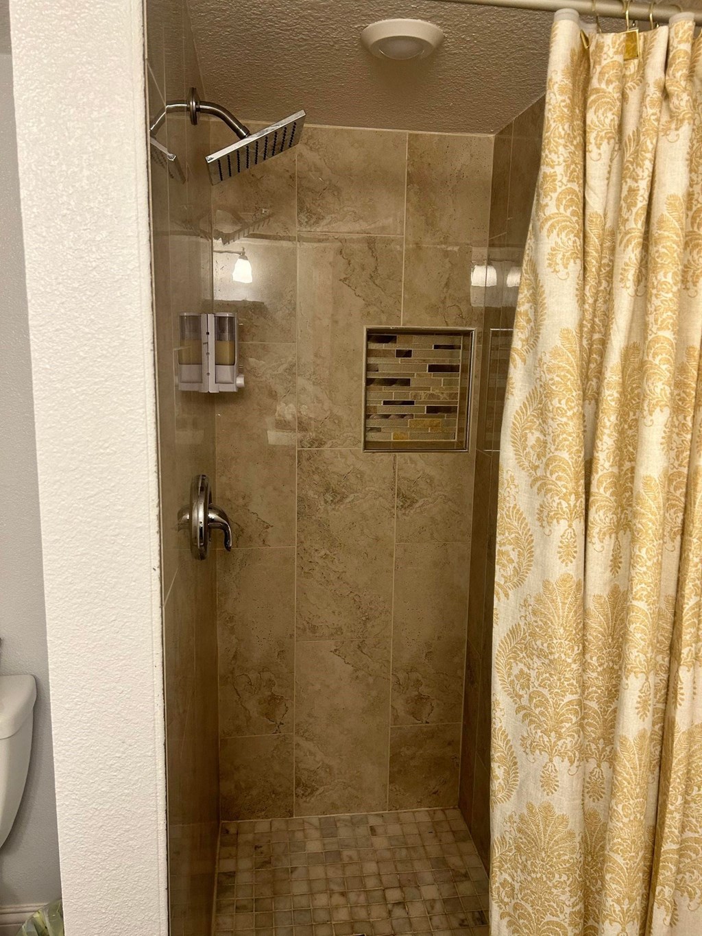 a tiled shower with a curtain in a bathroom