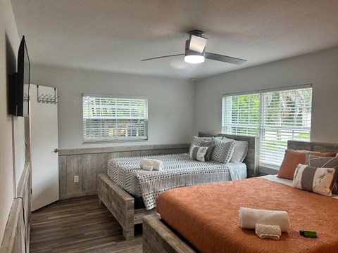 a bedroom with two beds and a ceiling fan