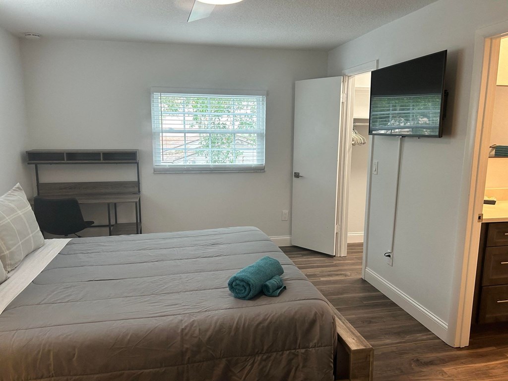 a bedroom with a large bed and a tv