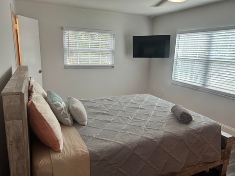 a bedroom with a bed and a tv on the wall