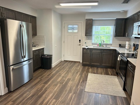 a kitchen with stainless steel appliances and wooden floors