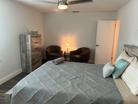 a bedroom with a large bed and two chairs