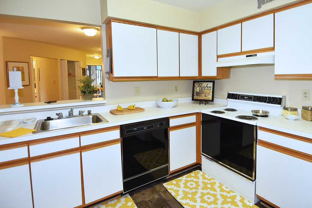 a kitchen with white cabinets and a black oven and a sink