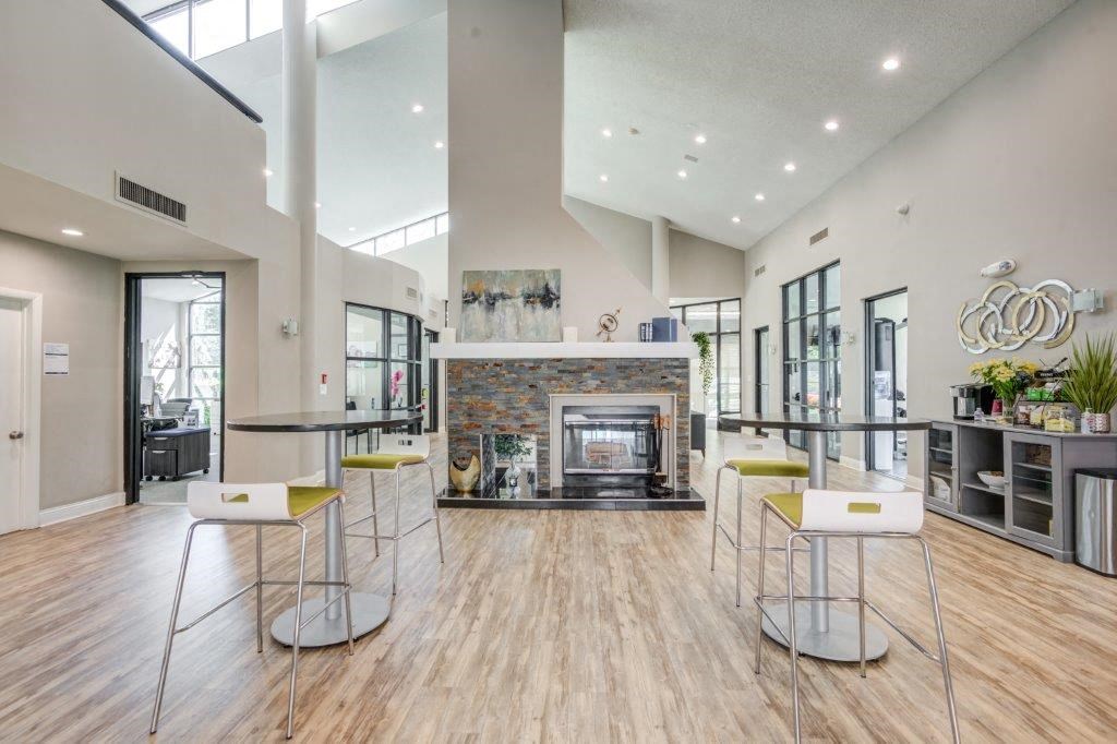 a spacious living room with a fireplace and bar with stools
