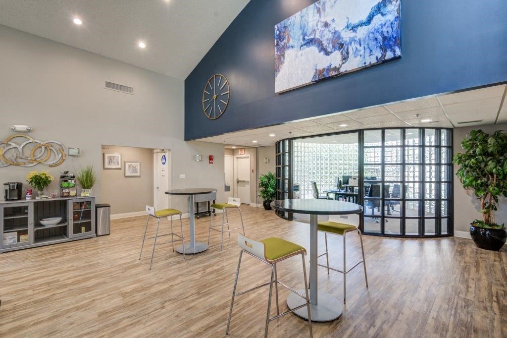 a lobby with tables and chairs and a large glass door