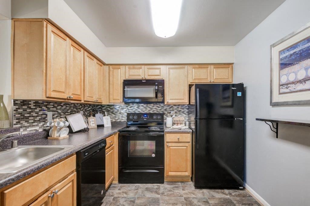 a kitchen with black appliances and wooden cabinets