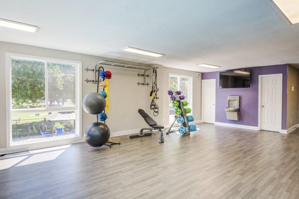 a workout room in a home with purple walls and a large window