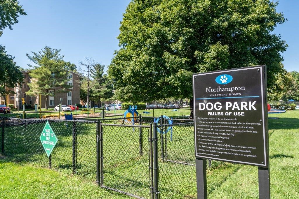 a dog park in a park with a sign