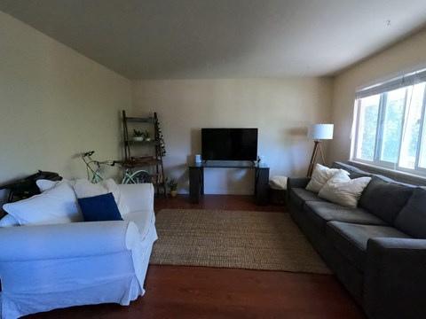 A living room with a white couch and a grey couch.