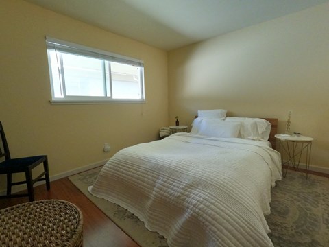 A bedroom with a large bed and a window.