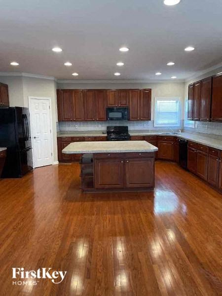 a large kitchen with a center island in the middle
