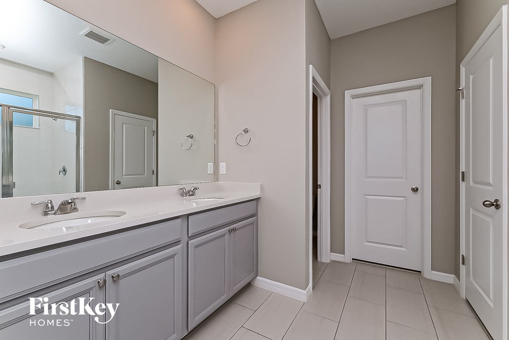 a white bathroom with a large mirror and two sinks