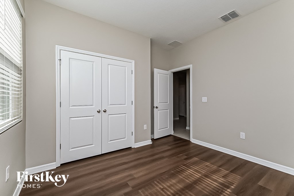 a bedroom with two closets and a door to a hallway