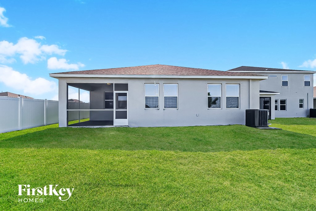 a white house with a lawn and a blue sky