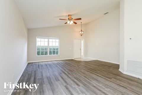 a living room with a ceiling fan and a window