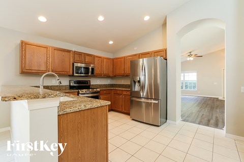 a kitchen with wooden cabinets and a stainless steel refrigerator