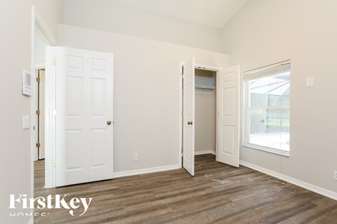 a bedroom with white doors and a door to a closet