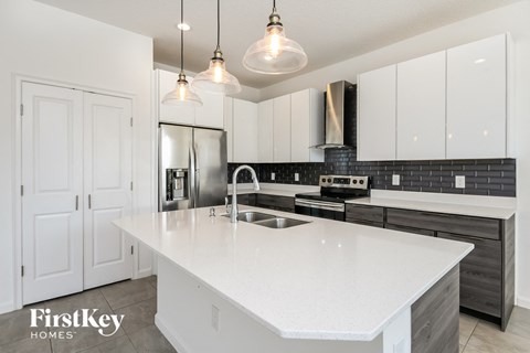 a white kitchen with white counter tops and black and white cabinets