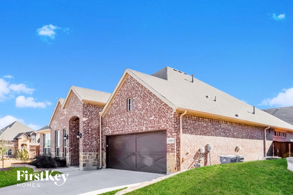 a brick house with a garage and a lawn