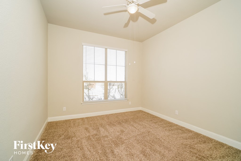 a bedroom with carpet and a ceiling fan