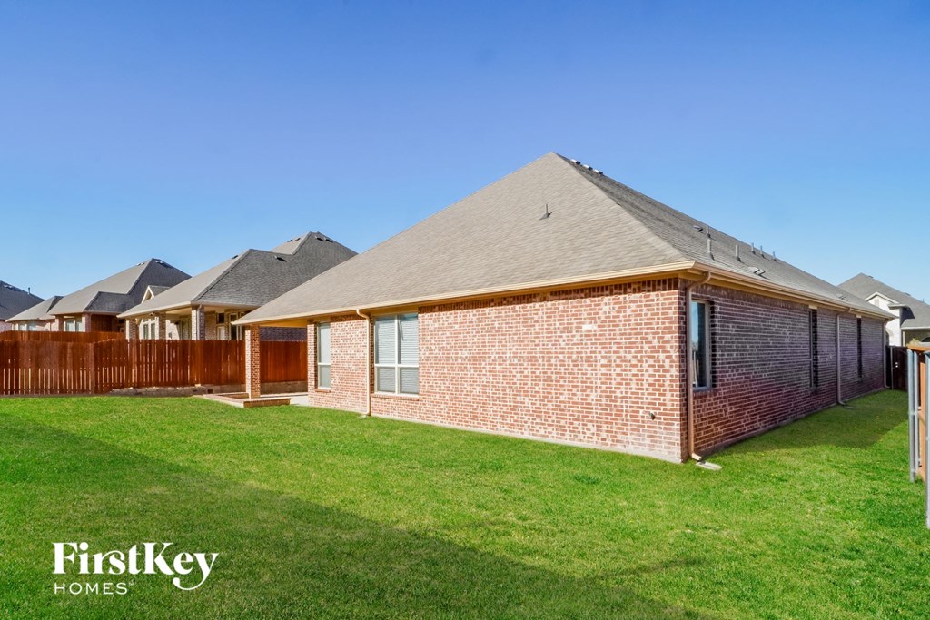 a brick house with a yard and a wooden fence