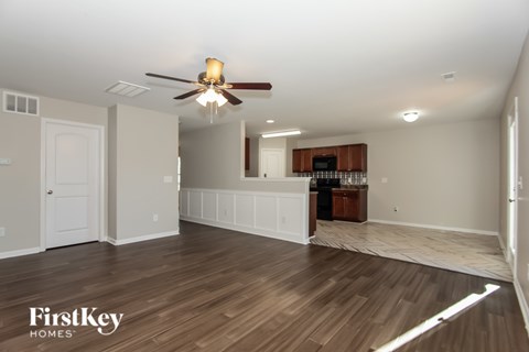 A spacious room with a ceiling fan and wooden flooring.