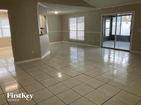 A spacious room with tile flooring and a sliding glass door.