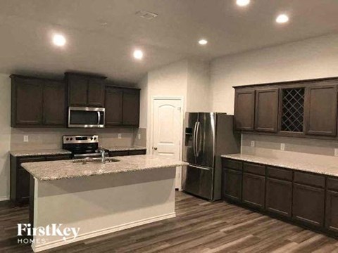 A kitchen with wooden cabinets and a granite countertop.
